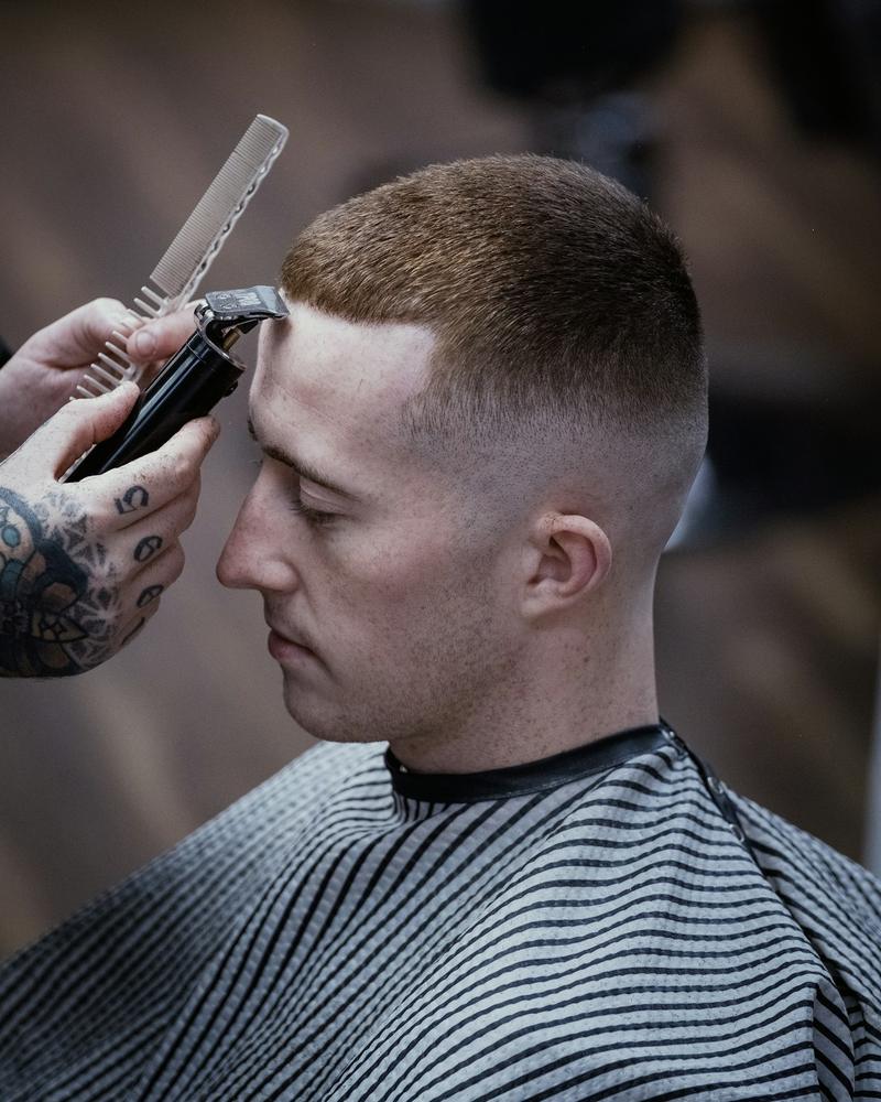 A short back and sides being finished with clippers and a comb
