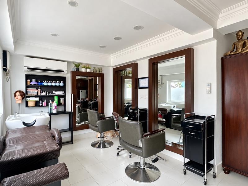 Inside the studio: two styling chairs and mirrors, the basin and shelves of colour