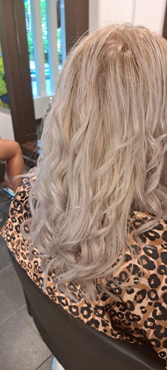 Long, softly waved hair in icy silver blonde, seen from behind